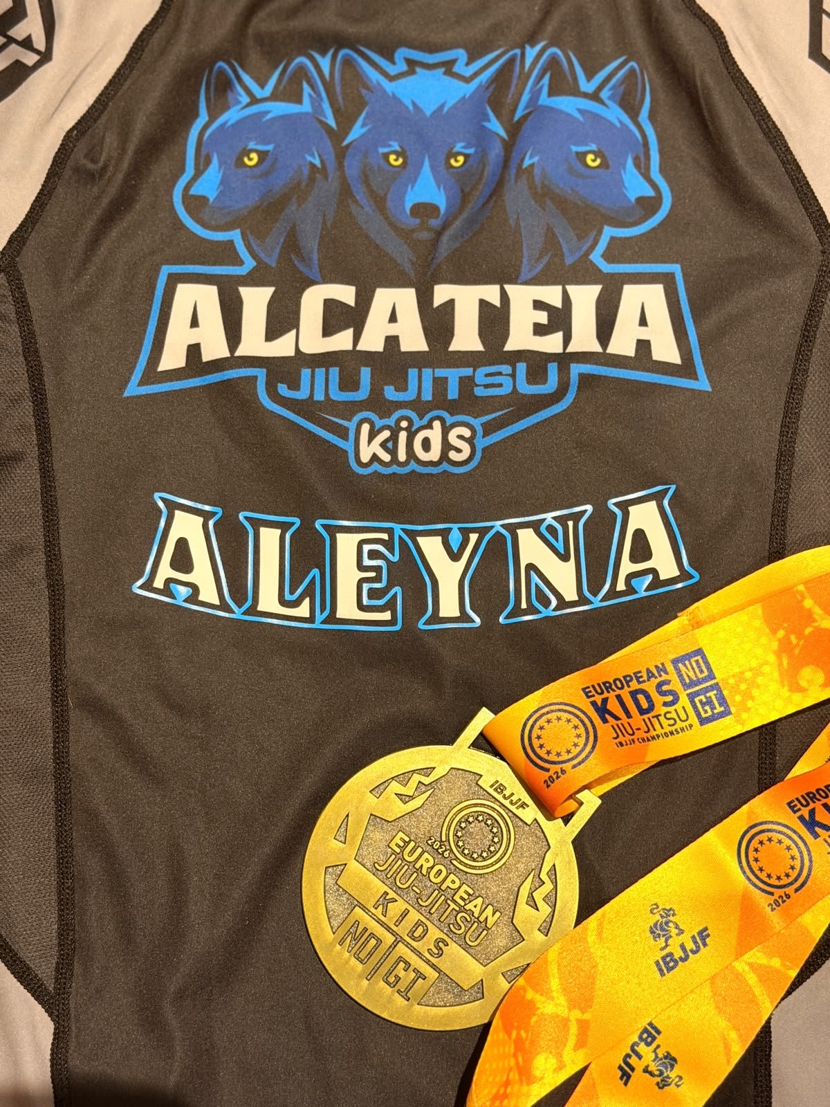 Aleynas Alcateia-Rashguard mit ihrem Namen und der Bronzemedaille der European Kids No-Gi IBJJF Championship 2026.