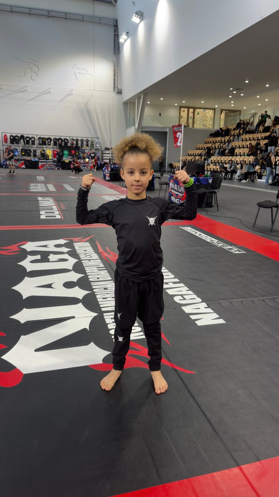 Aleyna zeigt ihre Muskeln auf der Matte an der NAGA Paris, März 2026.