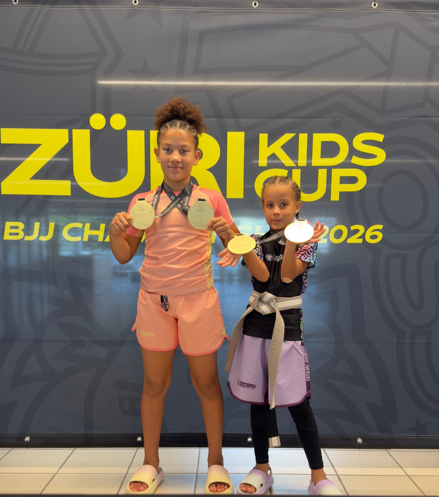 Aleyna und ihre Schwester zeigen ihre Medaillen vom Züri Kids Cup BJJ Championship 2026.